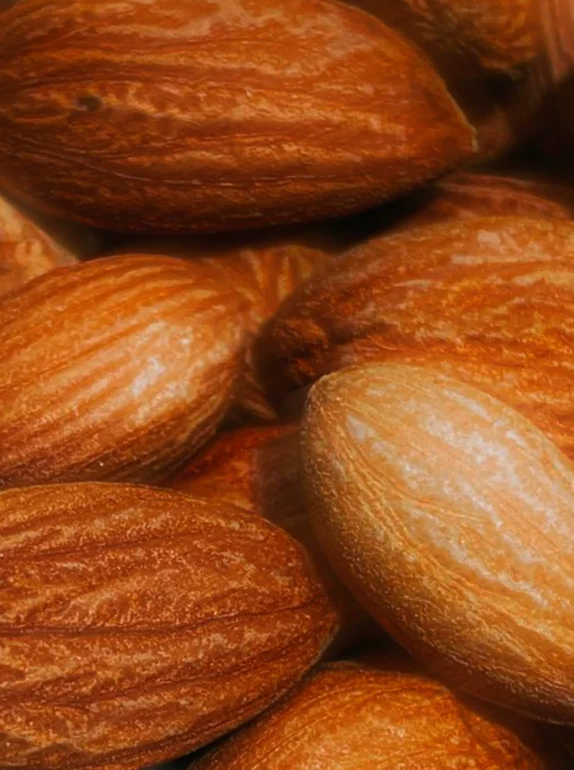 Amandes entières brillantes dans des tons chauds, textures poreuses et couleur dorée. Sérum perfecteur de pigmentation proposé. Unifie et hydrate.