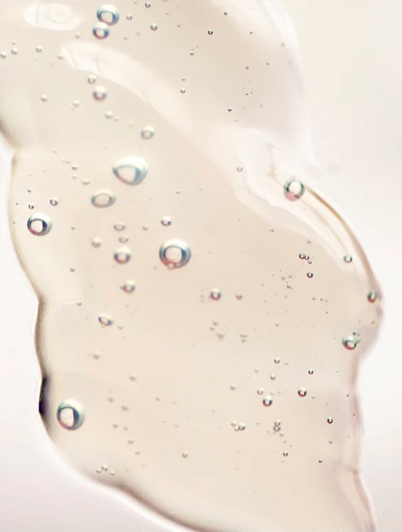 Gel transparent avec petites bulles, représentant une texture légère et hydratante pour la peau, en lien avec le gel double hydratation +HA - Lisse et repulpe
