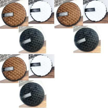 Éponge démaquillante pour le visage ronde, texture nid d’abeille, couleur bronze, noir et blanc, présentée sur une surface en bois.