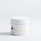 Masque à l’argile pour les pores dilatés et les points noirs, pot blanc minimaliste posé sur fond blanc.