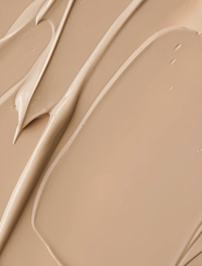 Crème solaire SPF30 teintée en texture légère beige, montrant un contour lisse et fluide sur fond uniforme.