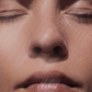 Crème solaire SPF30 teintée appliquée sur un visage ferme et éclairé, peau satinée et naturelle.