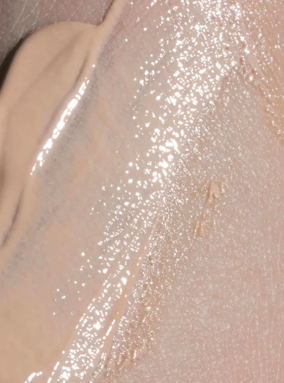 Crème solaire SPF30 teintée, texture fluide et couvrante appliquée sur la peau, couleur beige légèrement rosée.